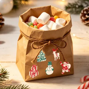 Détail d'autocollants de Noël festifs appliqués sur un sac cadeau en papier kraft brun.