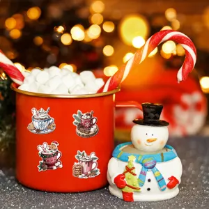 Detail view of festive Christmas watercolor stickers applied on a red mug for decor.