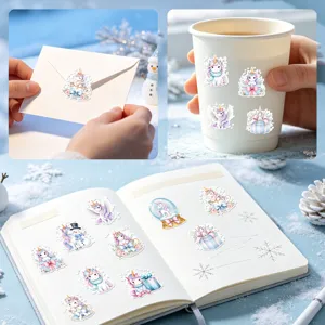 Süße Einhorn-Weihnachtsaufkleber auf einem Becher, Notizbuch und einem Briefumschlag.