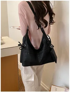 Large black soft leather shoulder bag with side bow detail and matching mini pouch