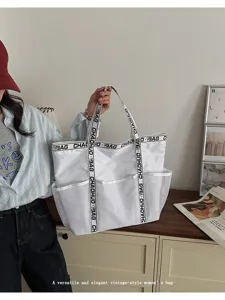 Nahaufnahme einer weißen Netztasche mit bedruckten Trägern in einer Lifestyle-Szene