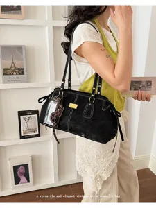 Lifestyle-Ansicht eines Models mit einer schwarzen Vintage-Schultertasche mit Kontrastnähten