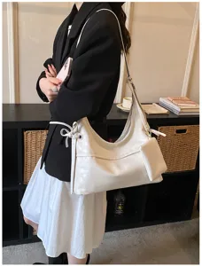 Model wearing white soft leather hobo shoulder bag with matching small pouch detail.