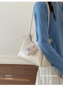 Detailaufnahme einer minimalistischen weißen Tragetasche mit süßem Kaninchen-Plüschtier