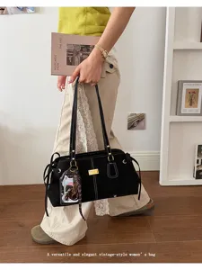 Detail einer schwarzen Vintage-Baguette-Tasche mit weißen Nähten am Modell