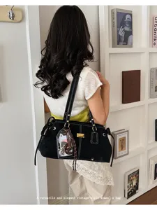 Elegantes Model mit schwarzer Vintage-Umhängetasche in einem stilvollen Raumdekor.