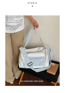 Model holding a white star-print canvas travel bag with a light blue strap and front pocket.