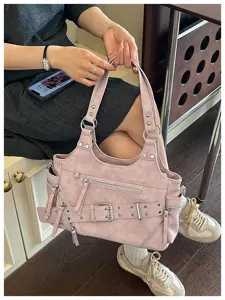 Detailopname van roze retro motor-tote bag met klinknagel gesp en ritsen vastgehouden door model.