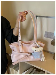 Detailansicht einer rosa Umhängetasche im koreanischen Stil mit Gürtelschnalle und Plüschtier