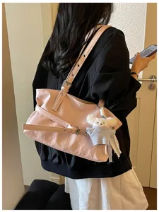 Lifestyle-Detailansicht einer rosa koreanischen Pendeltasche mit Schnalle und Plüschbär