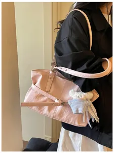 Stilvolle rosa Umhängetasche aus Kunstleder mit Gürtelschnalle und süßem Bärenanhänger