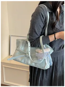 Seitenansicht einer hellblauen Lederschultertasche mit Schnallendetails am Modell