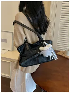 Schwarze Umhängetasche mit Schnalle im koreanischen Stil, am Modell im Innenraum