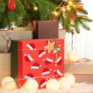 Detalle de pegatinas de gorro de Navidad con purpurina roja en una caja de regalo festiva.