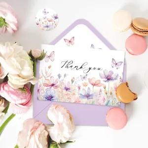 Détail d'une carte de remerciement florale avec enveloppe mauve et fleurs