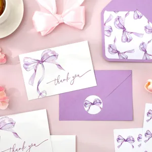 Detalle de set de tarjetas de agradecimiento con lazo acuarela púrpura, sobre y sticker