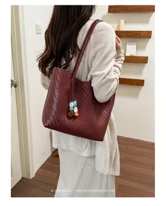 Bolso tote burdeos trenzado llevado al hombro para un estilo retro minimalista