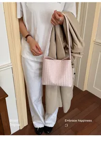 Close-up detail showing a pink woven shoulder bag paired with a white casual outfit
