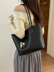 Elegante bolso tote grande de cuero trenzado negro con dijes de piedras de colores