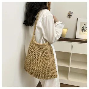 Detalle de un bolso de malla beige tejido a mano llevado por una modelo con ropa informal.