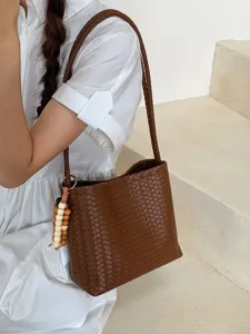 French style brown woven shoulder bag with beaded tassel accessory shown on model