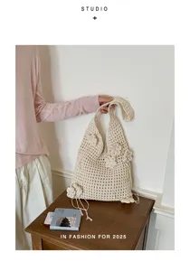 Detailansicht einer cremefarbenen Häkeltasche mit kunstvollen 3D-Blumenakzenten.