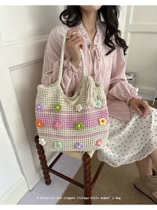 Detail view of a handmade crochet tote bag featuring colorful 3D flower decorations and tassels