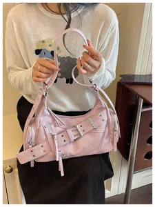 Vista dettagliata di una borsa moto rosa con borchie argentate e fibbie a cinturino