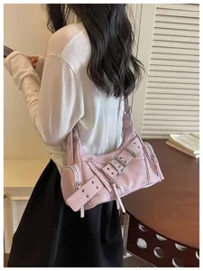 Dettaglio di una borsa a tracolla rosa stile moto con borchie e fibbie decorative