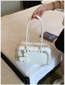 Close-up detail of white minimalist soft leather shoulder bag with a small coin purse attachment