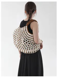 Mannequin portant un sac à bandoulière en perles de bois fait main pour la plage.