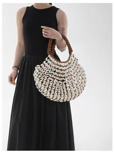 Vue détaillée du sac de plage en perles de bois fait main porté par un mannequin en studio