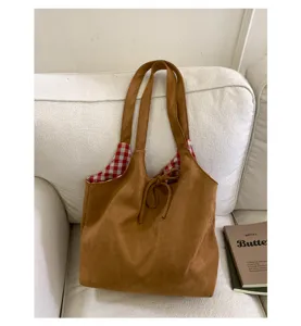 Close-up of the vintage brown suede tote bag with its red checkered lining texture