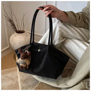 Détail du sac cabas vintage noir avec un joli pendentif en forme d'ours brun