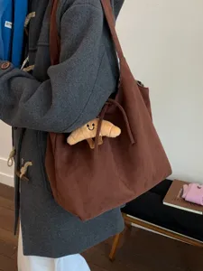 Large brown vintage suede shoulder bag with cute croissant charm for daily commute