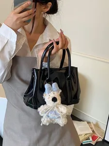 Sac à main élégant en cuir verni noir avec un adorable charme d'ours en peluche