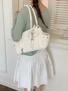 Weiße Motorrad-Tasche mit Nieten und Herzanhänger für modische Sommer-Outfits.