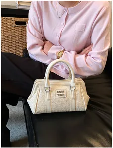Vue détaillée d'un petit sac cabas crème texturé avec un cardigan rose très élégant