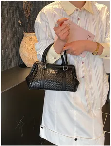 Élégant sac à main noir à texture tressée présenté dans une tenue moderne et chic.