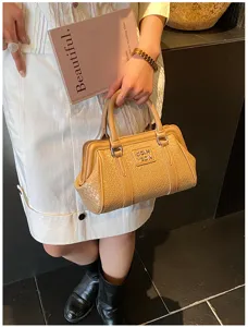 Femme tenant un sac à main beige à texture tressée pour un look d'été chic.