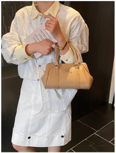 Détail d'un sac à main beige gaufré porté par un mannequin dans un cadre de style de vie.