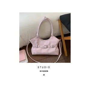 Elegante roze handtas van kunstleer met een decoratieve riem en zilveren gesp