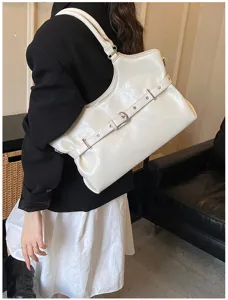 Detailopname van de glanzend witte tote bag voor onder de arm met gesp op model