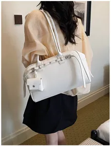 Minimalist white soft leather shoulder bag with decorative buckle and mini pouch charm.