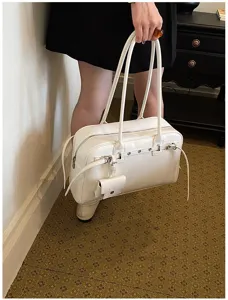 Detailed close-up of a minimalist white soft leather underarm shoulder bag with long straps