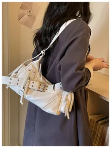 Vista laterale della modella che indossa una borsa da moto bianca vintage con fibbie