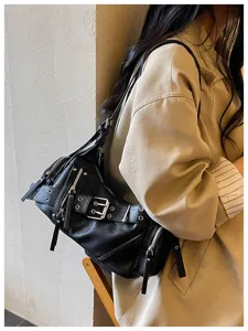 Dettaglio della borsa a tracolla stile biker nera con borchie argentate e fibbia