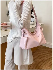 Close-up of pink soft faux leather hobo bag with matching mini pouch accessory