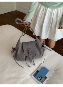 Stylish grey nylon hobo shoulder bag with buckle flap and drawstring detailing on white