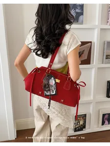 Elegante rote Vintage-Baguette-Tasche, die von einem Model in hellem Raum getragen wird